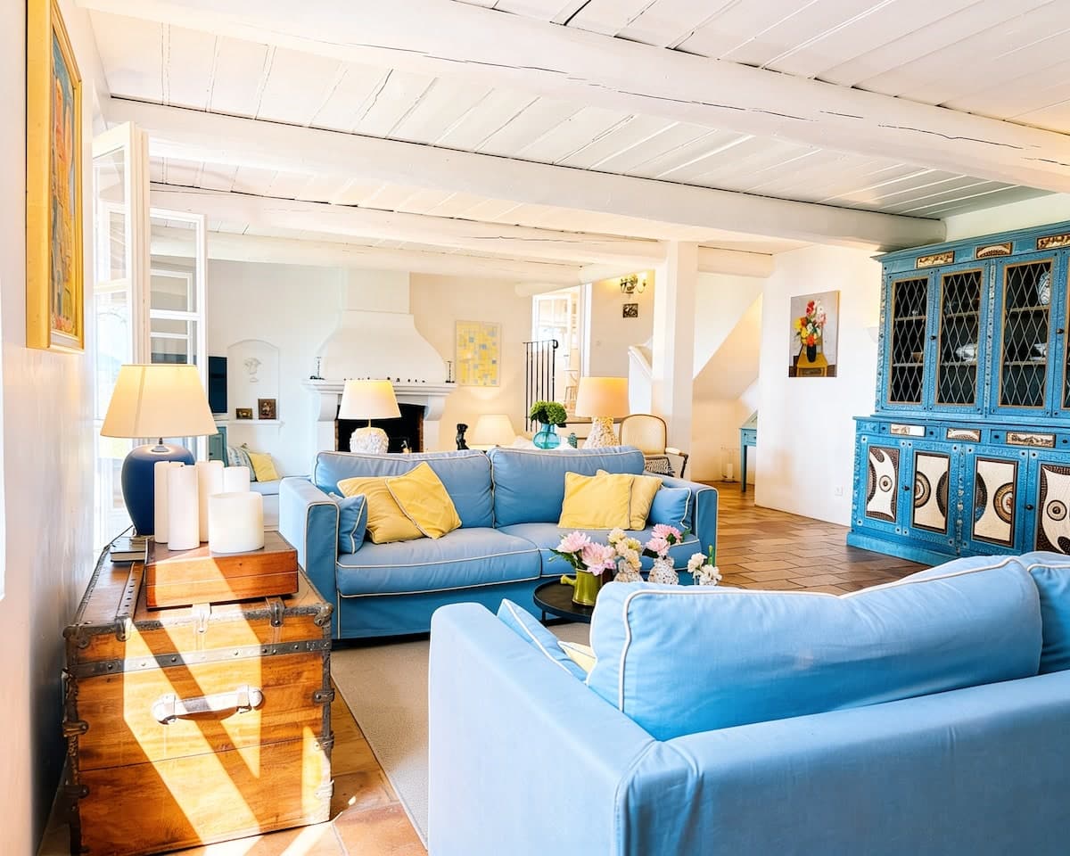 Living room with whitewashed beams, fireplace, and seating, view 1 of 11.